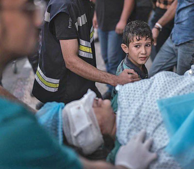 تصویری از بمباران های غزه که در شبکه های اجتماعی میلیون ها بازدید داشت.کودک فلسطینی که از بمباران اسرائیل جان سالم به در برده است، نظاره گر اعزام مادر مجروحش به بیمارستان است.